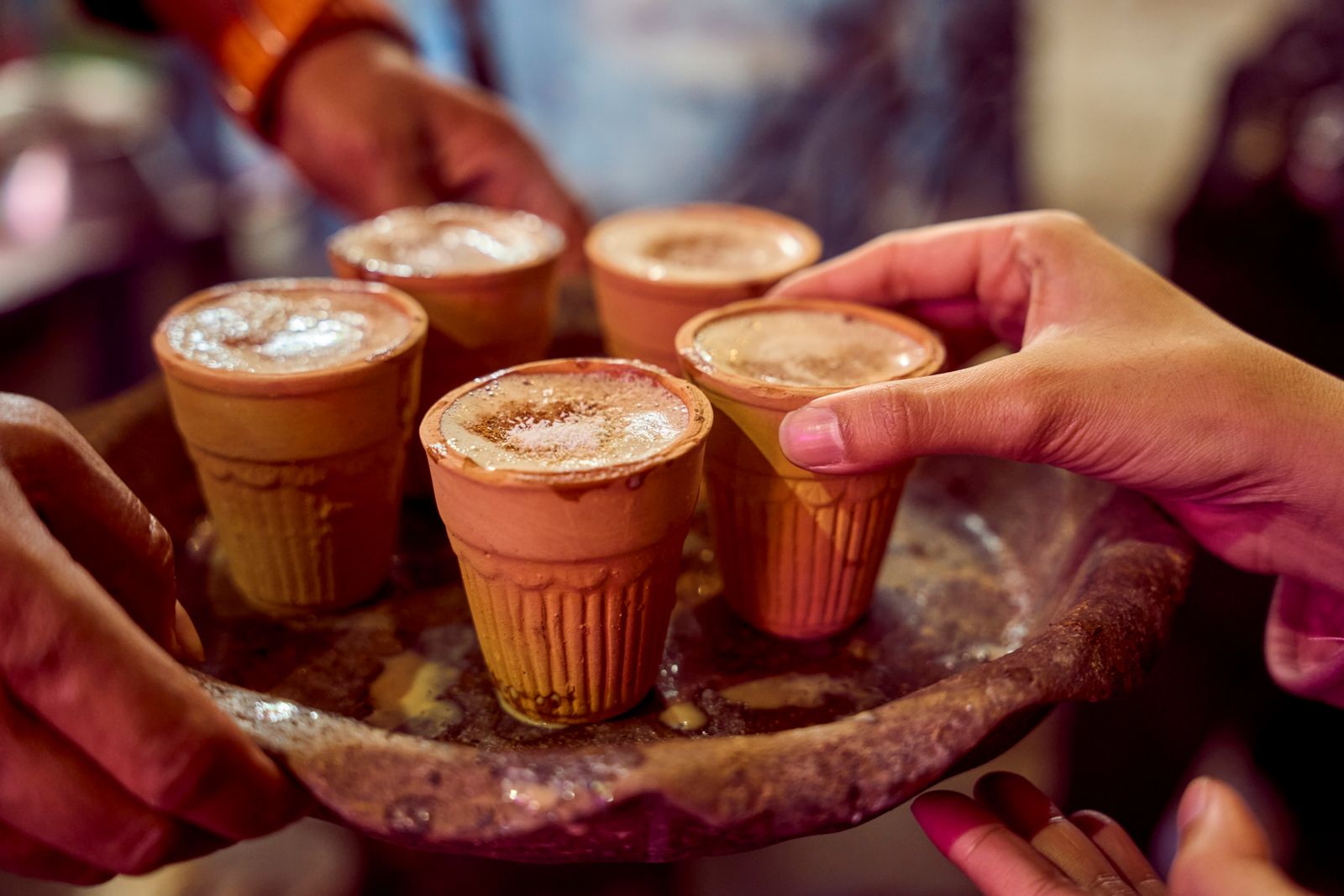 Clay cups of masala chai on a tray.