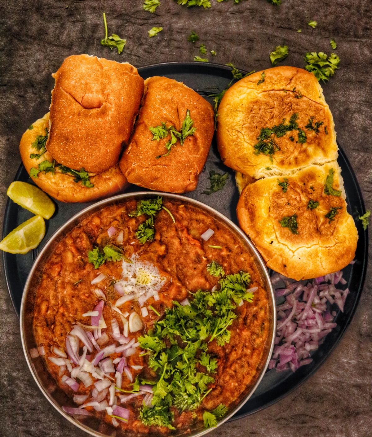 Pav bhaji with buttered pav, onion, coriander, and lime.