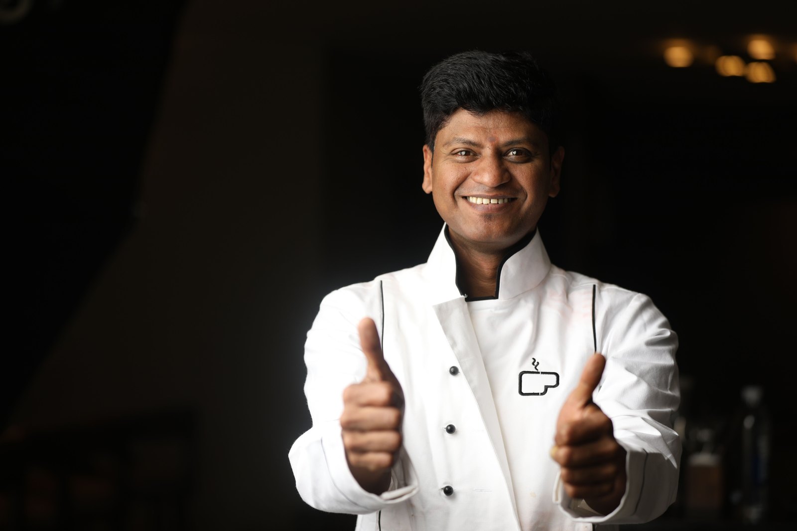 An Indian chef in a restaurant kitchen.