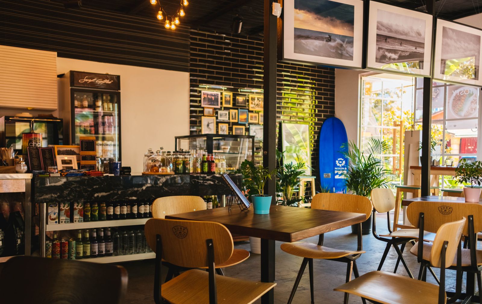 A cafe interior with wooden tables and the service counter.